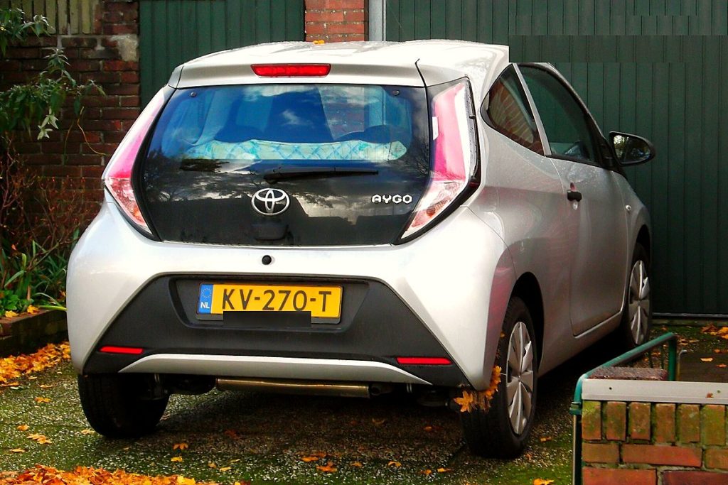Zilvergrijze Toyota Aygo met Nederlands kenteken, achteraanzicht
