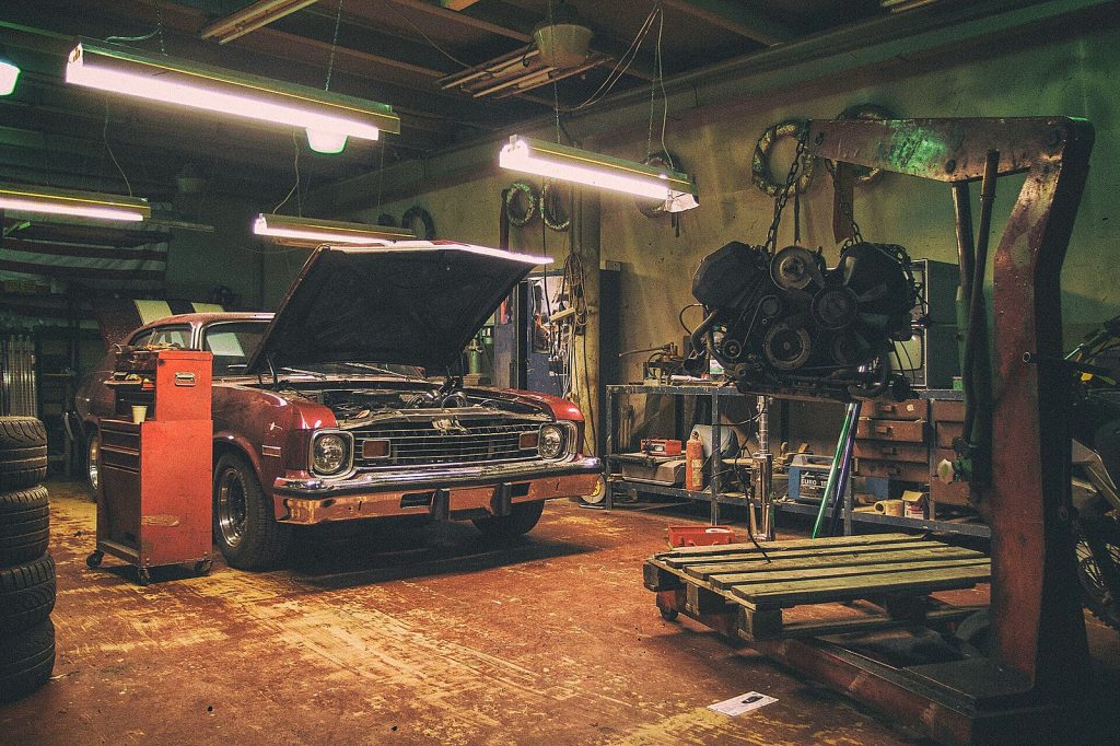 Klassieke auto met geopende motorkap in een werkplaats